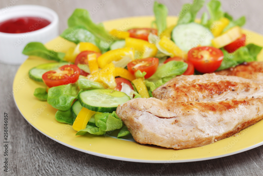 Grilled chicken breast with raw vegetables salad