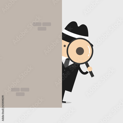 Detective holding a magnifying glass behind the wall.