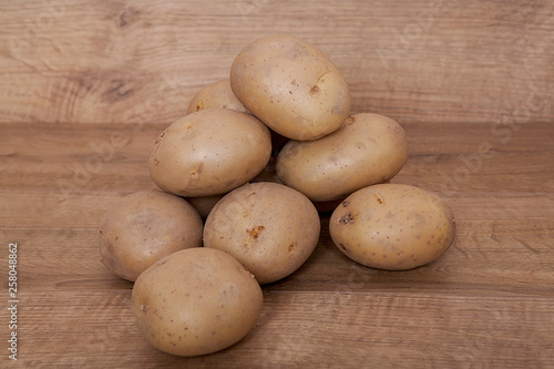 Potatoes on the wooden table.