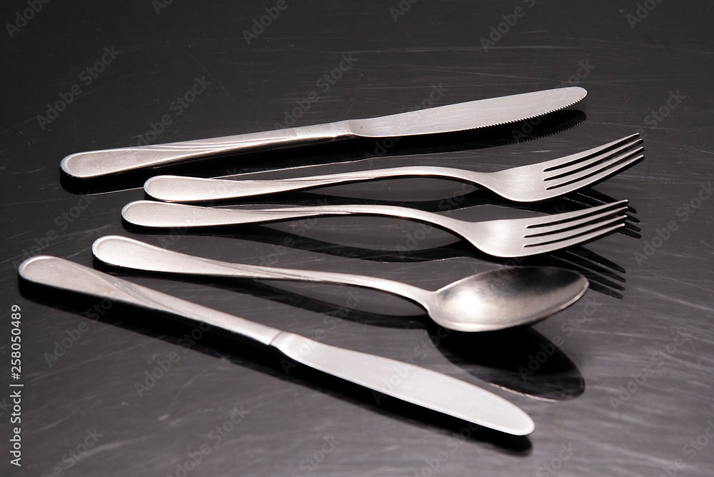 Two silver knives, two forks and a spoon are on the table Two silver knives, two forks and a spoon are on the table