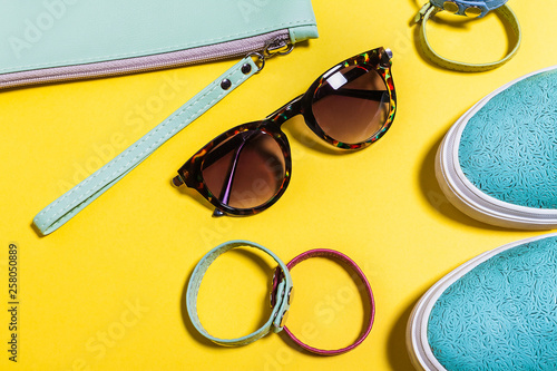 Stylish accessories for ladies. Fashionable sunglasses, colored bag, aquamarine shoes and little belts. Spring summer hipster trend. Top view. mockup for instagram. free copyspace photo