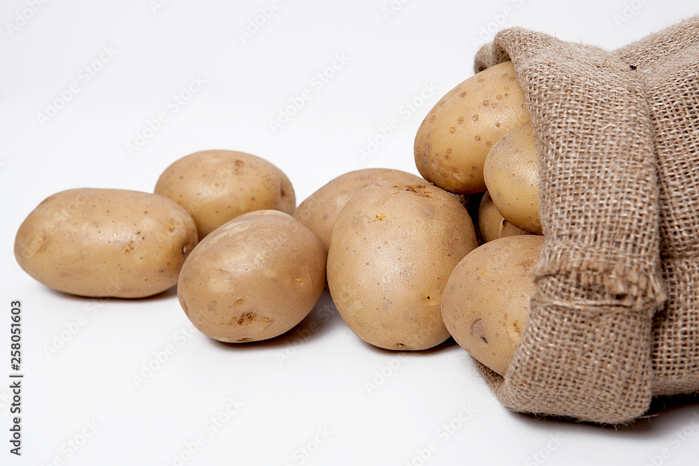 Fototapeta premium Burlap sack with potatoes on the white background.