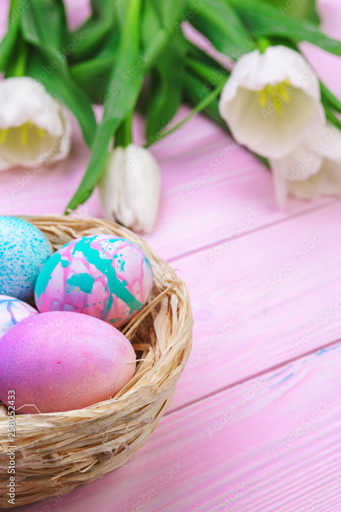 Easter background with colorful eggs and tulips over pink wood. Top view with copy space Easter background with colorful eggs and tulips over pink wood. Top view with copy space