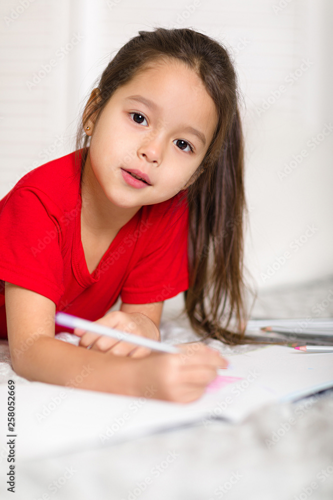 cute little child girl in red pajamas draws with pencils at home cute little child girl in red pajamas draws with pencils at home