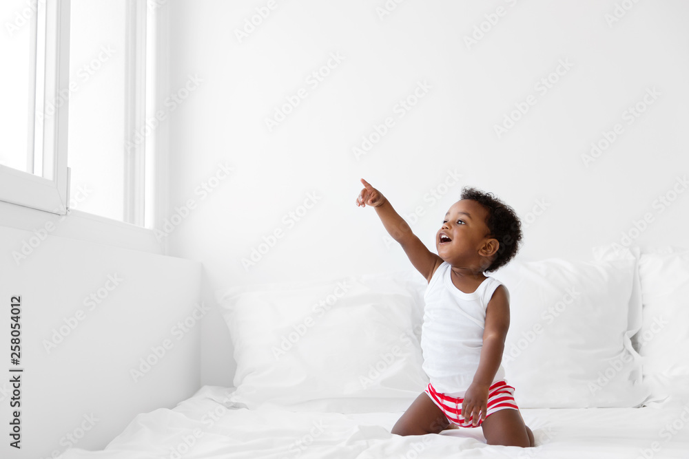 Toddler boy looking out by the window pointing with finger Toddler boy looking out by the window pointing with finger