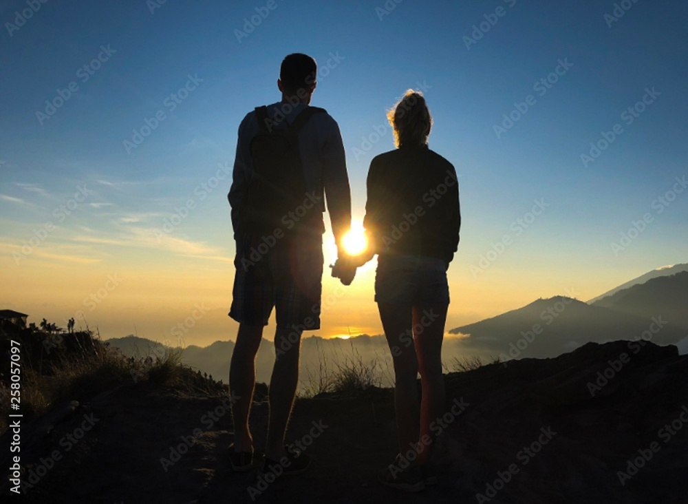 couple walking on the mountain at sunset