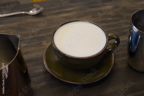 close up of glass cup with fresh milk on wooden table