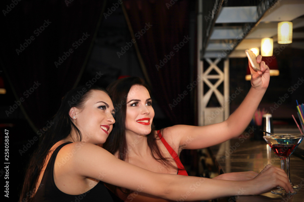 Portrait of two beautiful women taking selfie in a nightclub. Portrait of two beautiful women taking selfie in a nightclub.