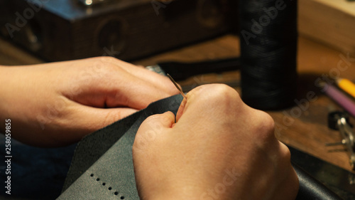 Leather handbag craftsman at work in a workshop