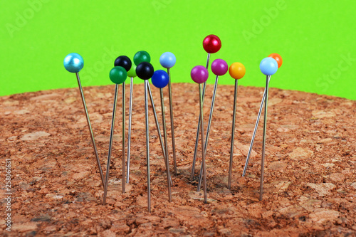 Multi colored push pins on corkboard