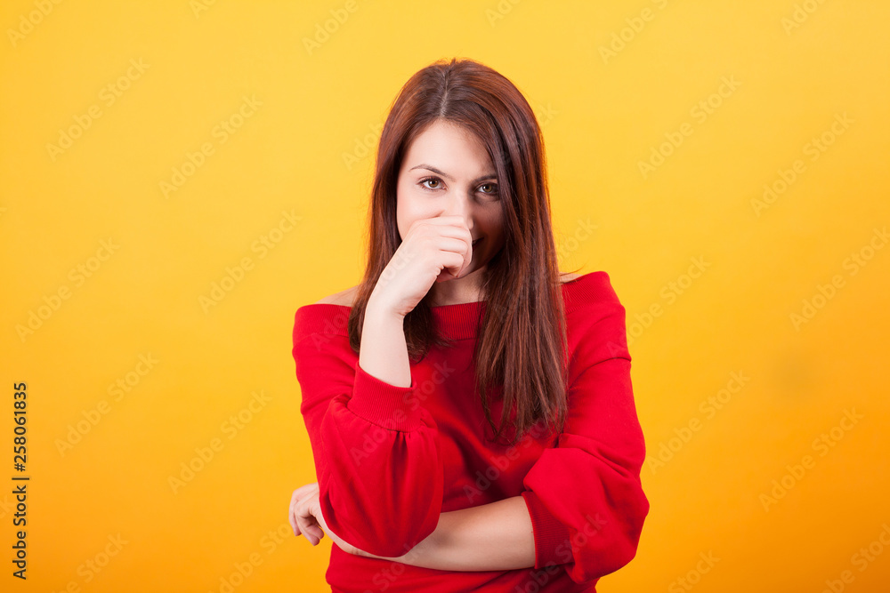 Image of beautiful young woman looking at the camera over yellow background Image of beautiful young woman looking at the camera over yellow background