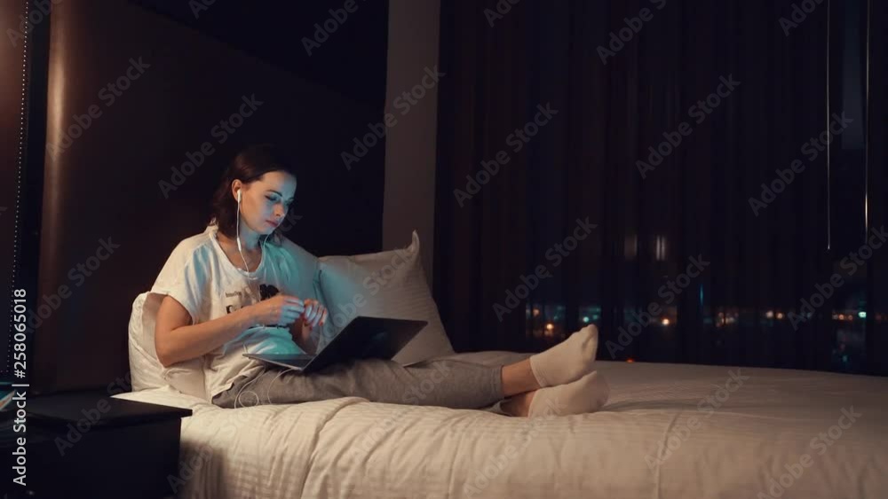 Young girl with a laptop on the bed in the hotel Young girl with a laptop on the bed in the hotel