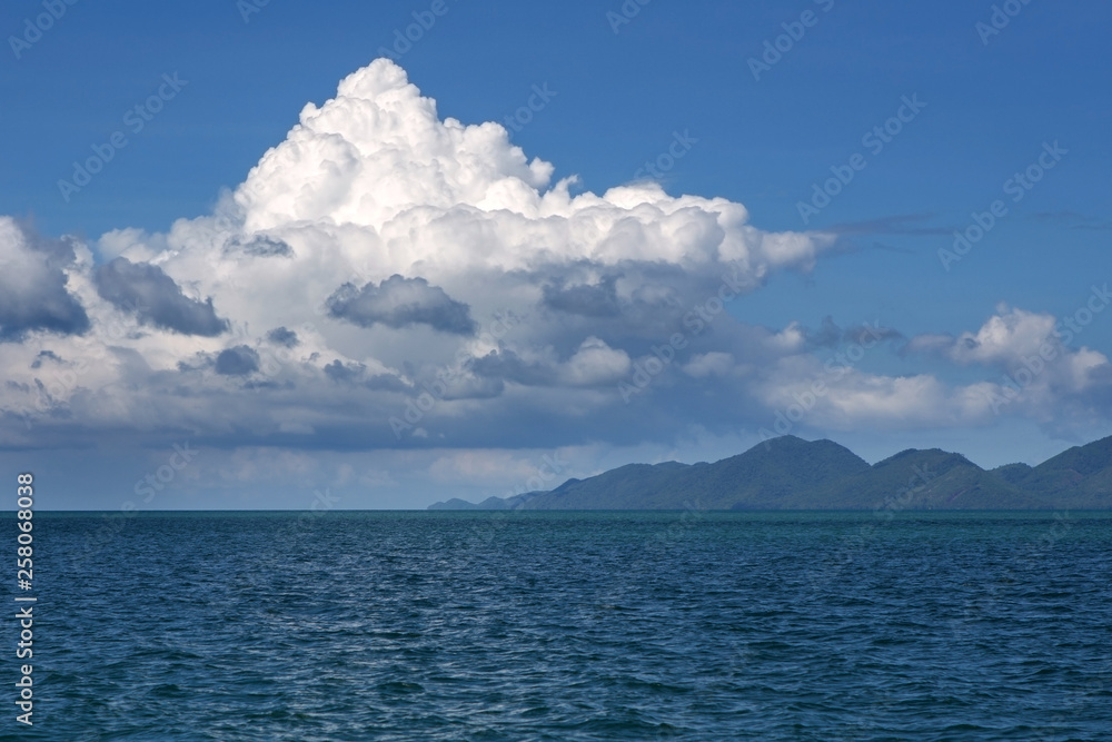 Seascape. Clouds, small hills on the horizon.