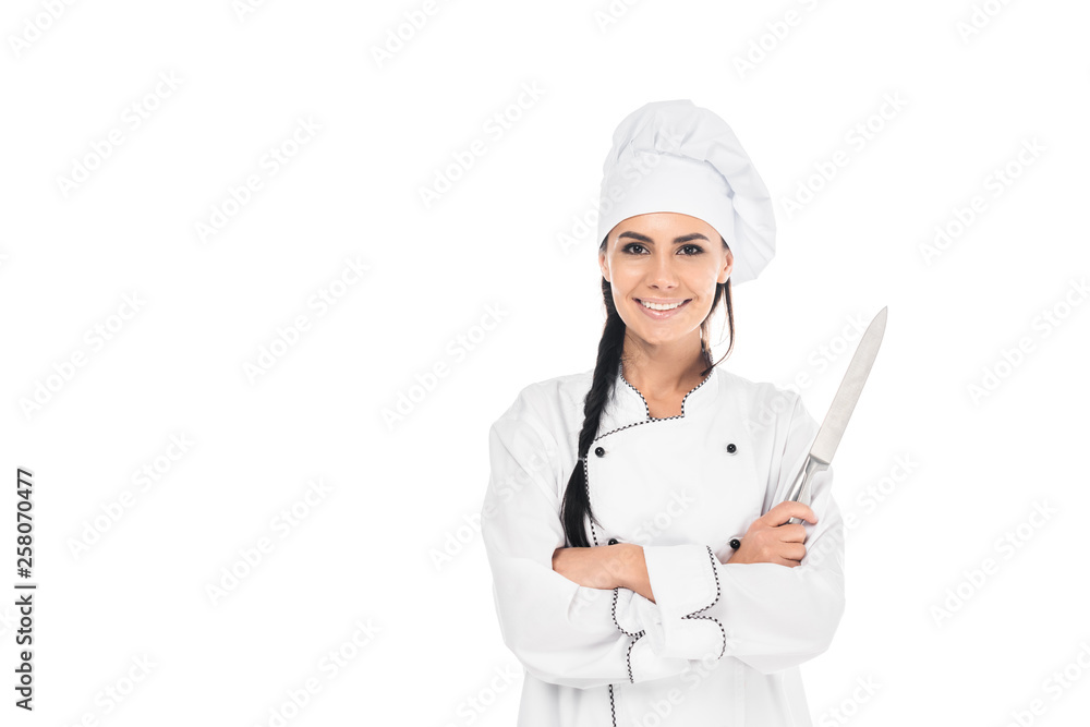 Smiling chef in uniform holding knife with crossed arms isolated on white Smiling chef in uniform holding knife with crossed arms isolated on white