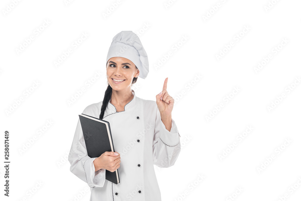Chef in uniform holding black book and showing idea gesture isolated on white Chef in uniform holding black book and showing idea gesture isolated on white