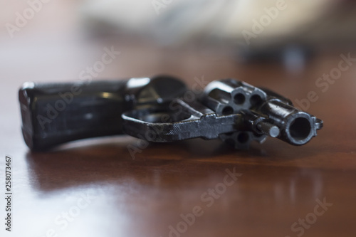 black one revolver lie on brown table
