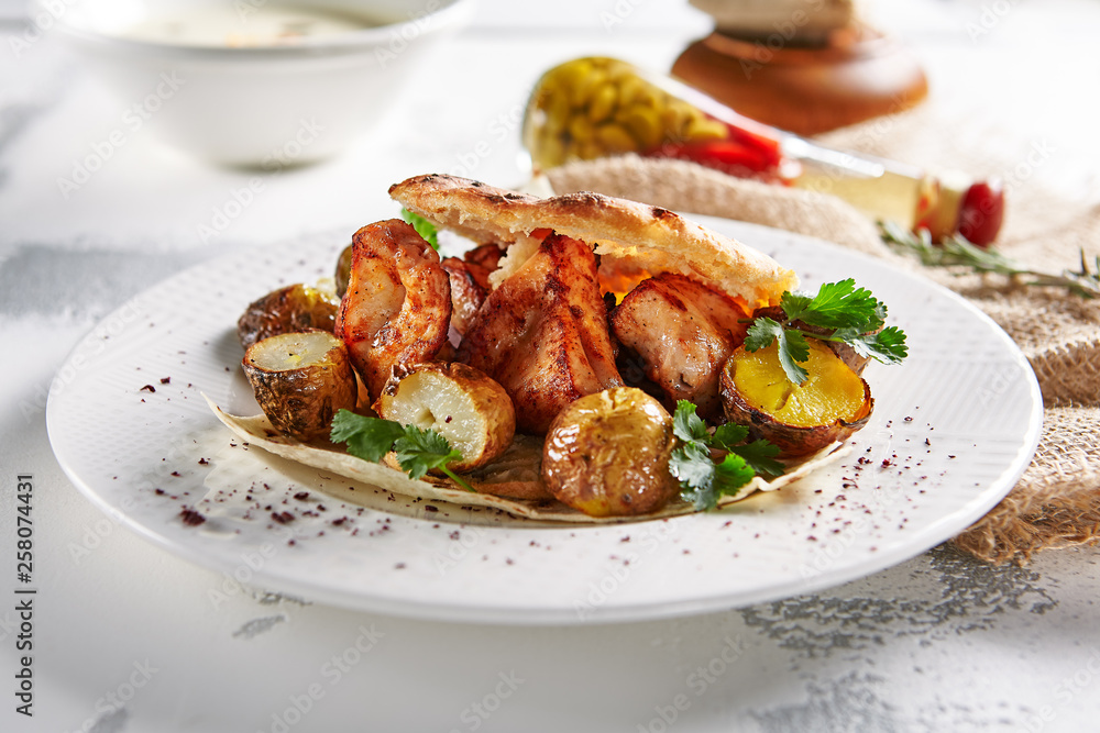 Grilled Pork with Potato, Spices and Pita Bread on Rustic Background