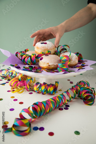 Wallpaper Mural Frau isst traditionelle Deutsche Berliner Pfannkuchen Krapfen zu Fasching, Karneval oder Silvester mit bunten Konfetti und Luftschlangen Torontodigital.ca