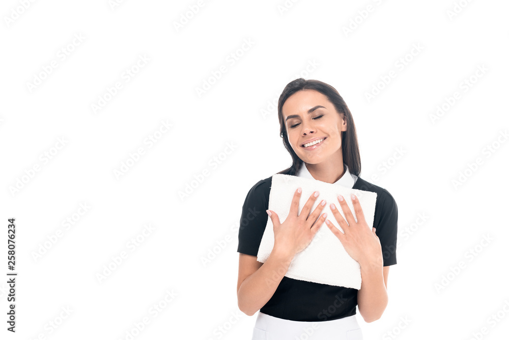 Smiling maid in uniform holding towels isolated on white Smiling maid in uniform holding towels isolated on white