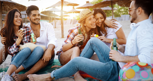 Group of young friends laughing and drinking beer
