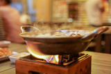 A hot pot streaming of shabu or nabe traditional food with smoke floating on top, look like delicious and fresh food from cooking, food menu concept.