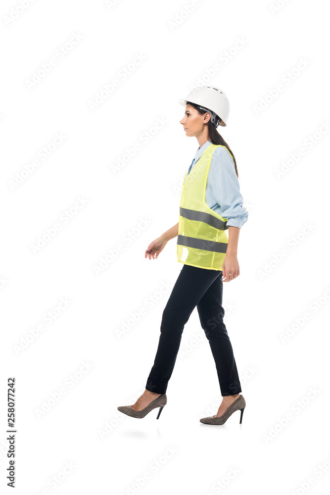 Side view of engineer in safety vest and high-heeled shoes walking isolated on white Side view of engineer in safety vest and high-heeled shoes walking isolated on white