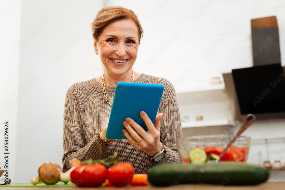 Cheerful good-looking lady with tied hair spending time on kitchen Cheerful good-looking lady with tied hair spending time on kitchen