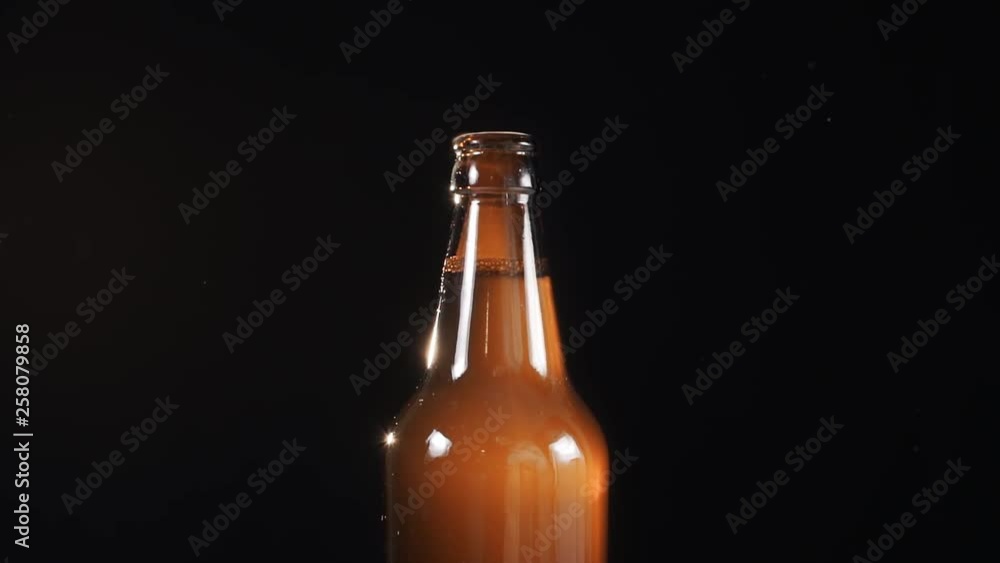 Using the beer bottle opener in slow motion on the black background, smoke comes from the bottle neck while opening, bubbles in drink, alcohol drink, noname bottle, dowscalled 4k 422 ProRes Using the beer bottle opener in slow motion on the black background, smoke comes from the bottle neck while opening, bubbles in drink, alcohol drink, noname bottle, dowscalled 4k 422 ProRes