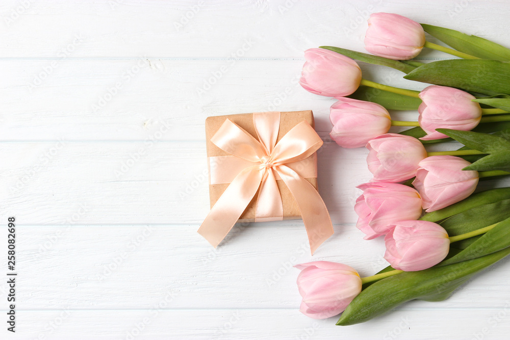 Beautiful composition for the Day of Mother on wooden background top view. Flowers, greeting card, gift. Beautiful composition for the Day of Mother on wooden background top view. Flowers, greeting card, gift.