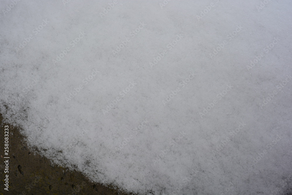Beautiful snow background, melting snow on a concrete structure, concrete wall with gray-brown color. Beautiful snow background, melting snow on a concrete structure, concrete wall with gray-brown color.