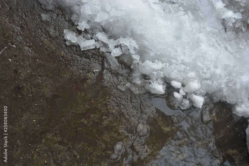 Beautiful snow background, melting snow on a concrete structure, concrete wall with gray-brown color. Beautiful snow background, melting snow on a concrete structure, concrete wall with gray-brown color.
