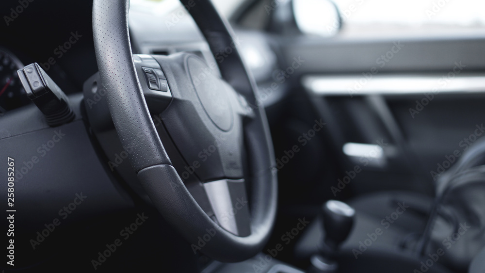 Interior view of car with black salon. Close-up Of Steering Wheel While