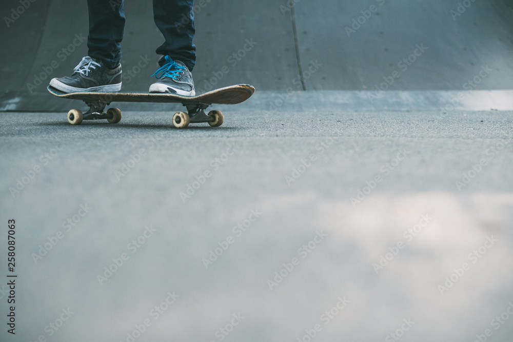 Man feet on skateboard. Skate park ramp. Urban hipster lifestyle. Colorful laces trend. Copy space for advertisement. Man feet on skateboard. Skate park ramp. Urban hipster lifestyle. Colorful laces trend. Copy space for advertisement.
