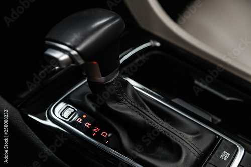 Сlose-up of the car black interior: dashboard, accelerator handle, parking systems, seats and other buttons.