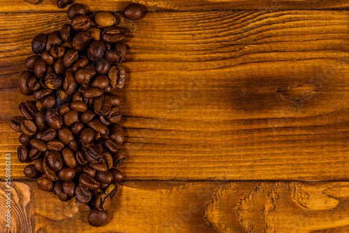 Pile of the coffee beans on wooden table. Top view