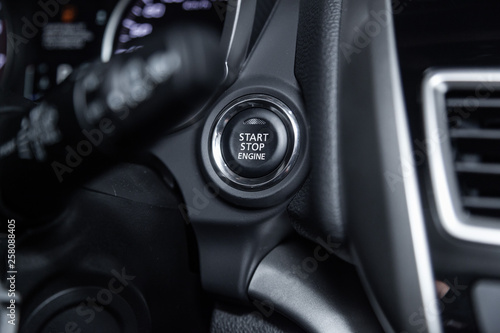 Сlose-up of the car grey interior: start stop engine button.
