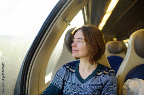 Portrait of a beautiful pensive girl dreaming in a train car. © Maria Sbytova