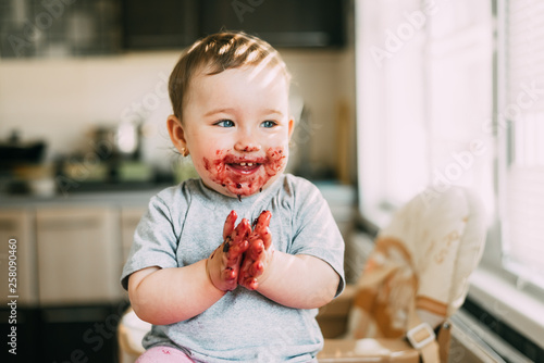 Fotografía portrait of a child smiling with a dirty face in red jam