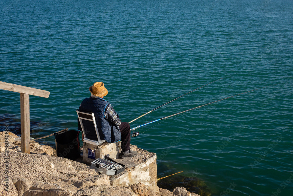 Senior man with hat fishing on sunny day