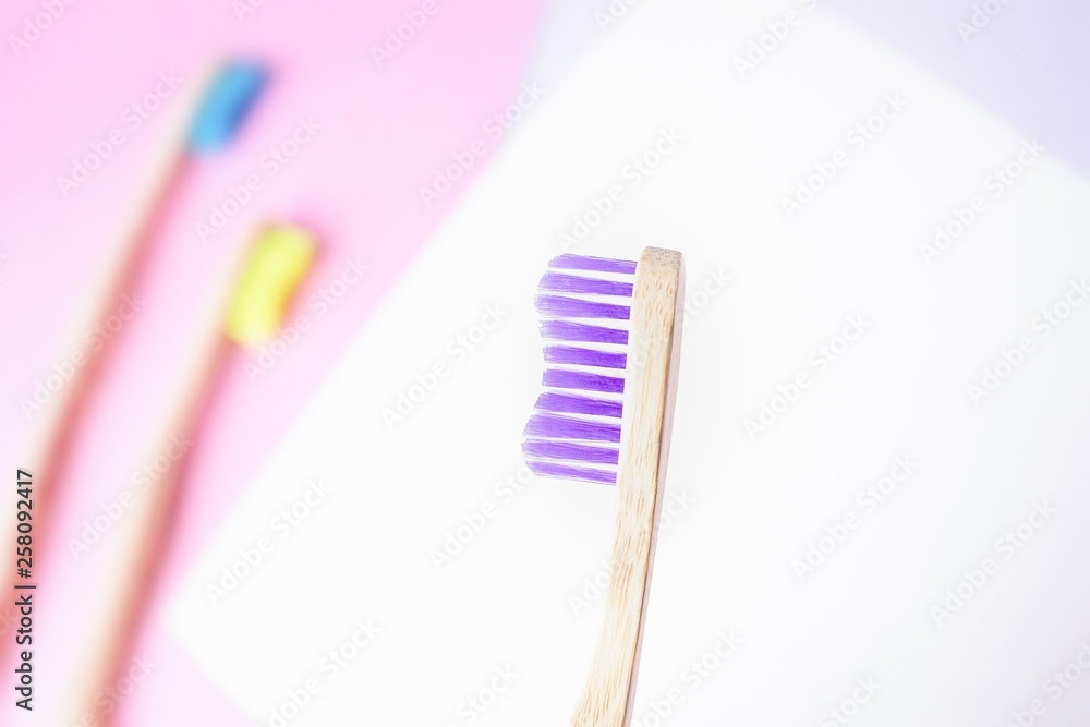Violet bamboo toothbrush. Eco-friendly concept. Minimal, colored geometric background. Top view, copy space Violet bamboo toothbrush. Eco-friendly concept. Minimal, colored geometric background. Top view, copy space