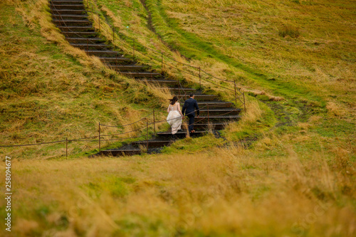 Beautiful wedding couple posing outdoor on wooden staris