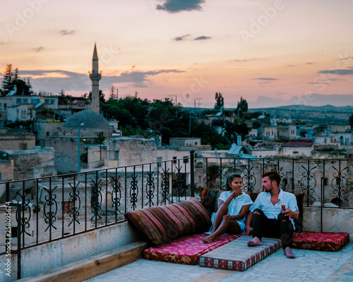 Photography happy couple with a drink on rooftop of an cave house historical village of Ayva