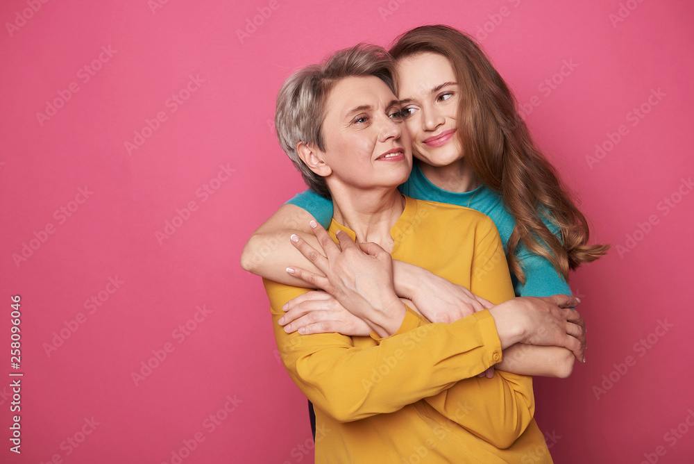 Beautiful woman with her charming daughter posing for camera Beautiful woman with her charming daughter posing for camera
