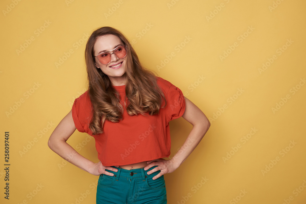 Waist up of smiling brunette young lady in eyeglasses posing for camera Waist up of smiling brunette young lady in eyeglasses posing for camera