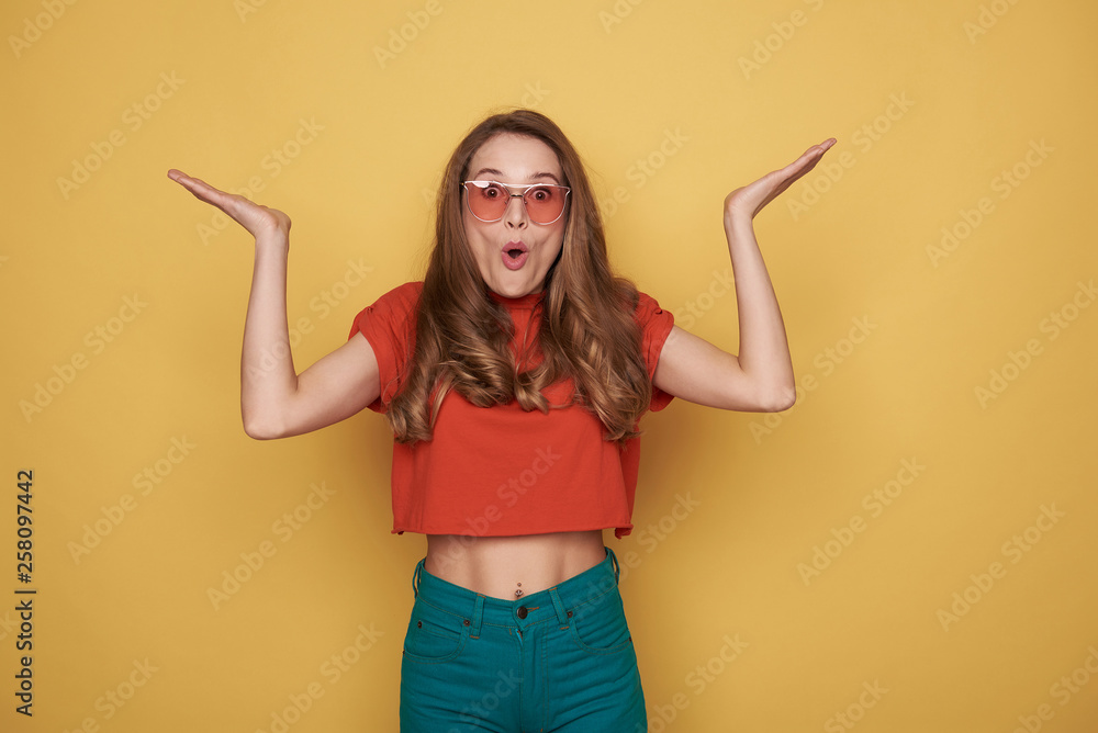 Waist up of unconfident brunette young lady in eyeglasses posing for camera Waist up of unconfident brunette young lady in eyeglasses posing for camera