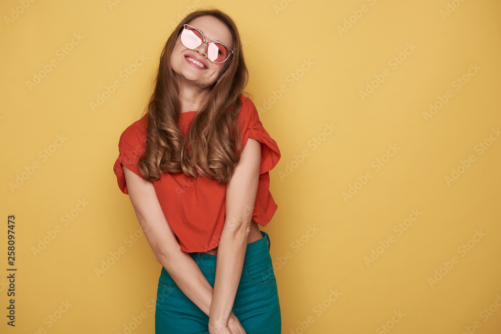 Waist up of smiling brunette young lady in eyeglasses posing for camera Waist up of smiling brunette young lady in eyeglasses posing for camera