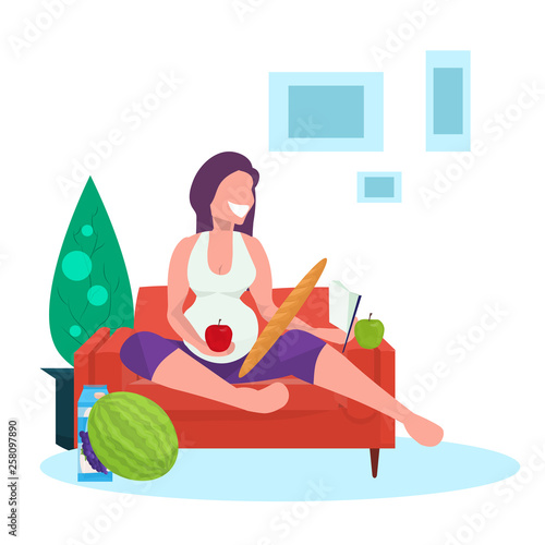 happy pregnant woman reading book and eating fresh fruits girl sitting on couch pregnancy and motherhood concept flat full length living room interior