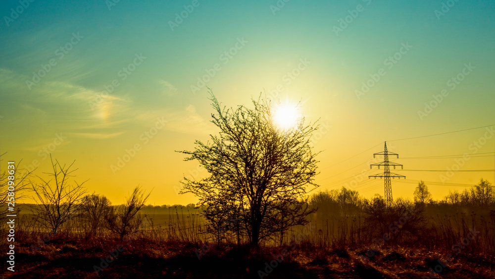 Sonnenaufgang über der Landschaft im Hintergrund Strommast.