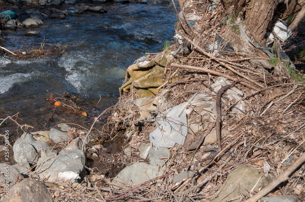 Fototapeta premium Plastic and foam garbage floating on the surface of the river