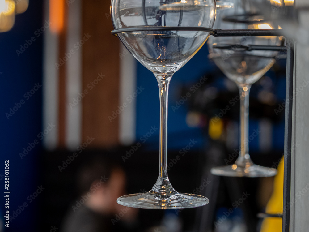 Obraz premium Image of a part of wine glasses hanging on a wall rack
